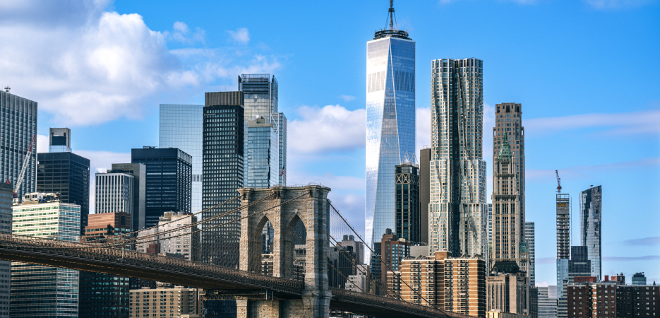 Photo of the New York City skyline against a blue sky.